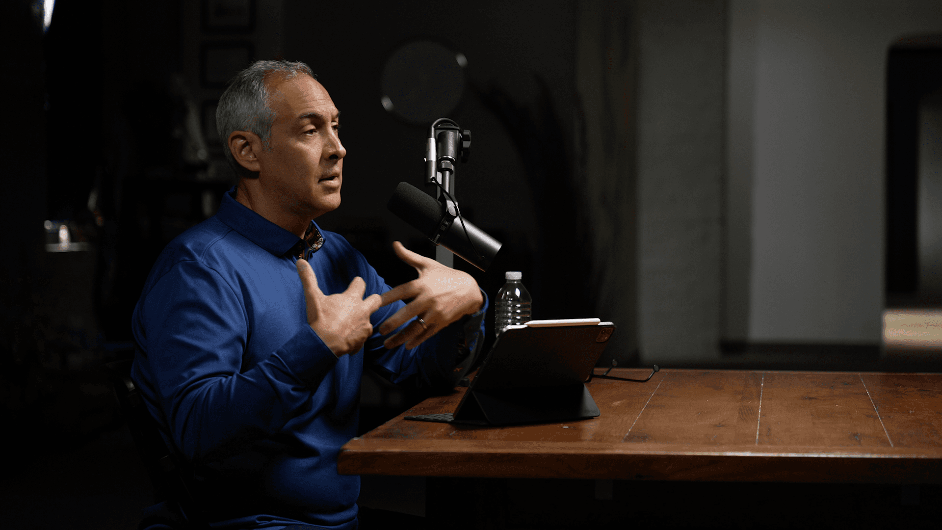 Tony Pisani recording a podcast episode at a table with a microphone.
